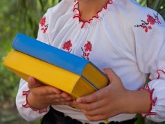 Best Ukrainian Books: A Definitive Guide for Avid Readers girl in embroidery books with color Ukrainian flag