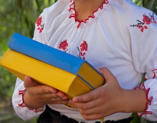 Best Ukrainian Books: A Definitive Guide for Avid Readers girl in embroidery books with color Ukrainian flag