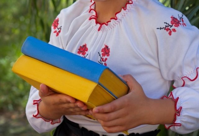 girl in embroidery books with color Ukrainian flag